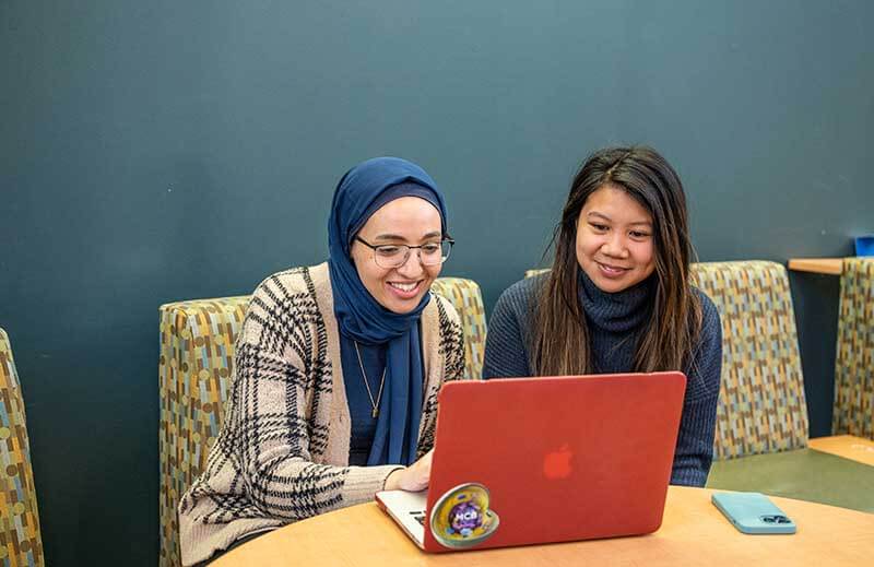 Two Female NEOMED Students Sitting and Working Together at a Laptop